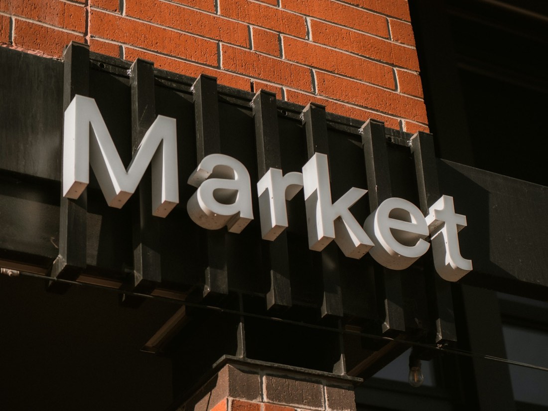 A 'Market' storefront sign on a brick building